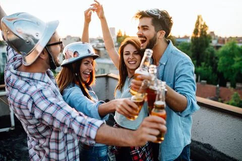 Happy group of friends with drinks having fun at rooftop party Stock Photos
