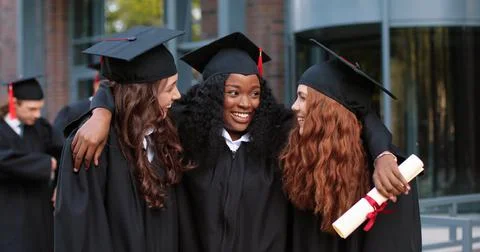 Happy group of mature students on graduation day embracing with each other Stock Photos