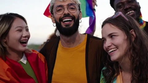 Happy group posing with rainbow flag for a fun event Stock Footage 276509969