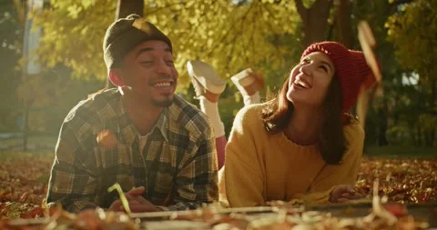 A happy guy with Black skin in a checkered shirt and his brunette girlfriend lie Stock Footage 299924797