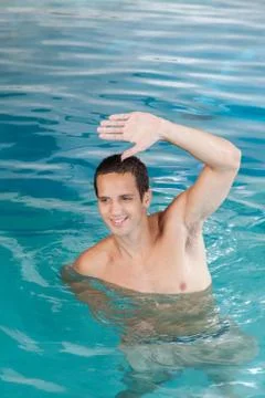 Happy guy exercising in the pool 스톡 사진