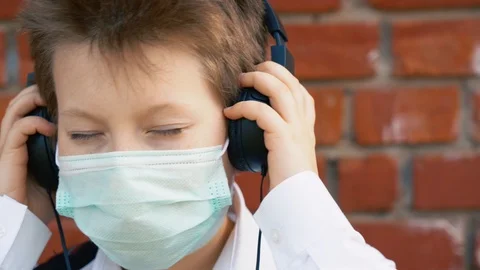 Happy guy in face mask, black headphones listen to music  slow motion close up. Stock Footage 127837490