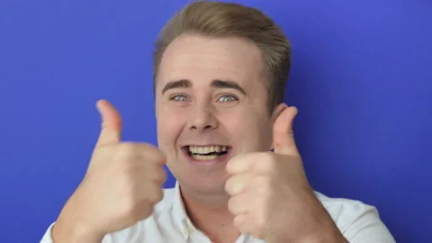 Happy guy gesturing thumb up and widely smiling Stock Footage 219541560