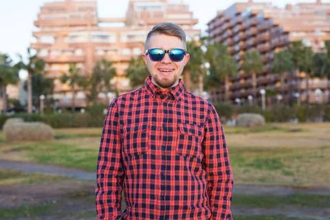 Happy guy looking sunset on background park and buildings Stock-Fotos