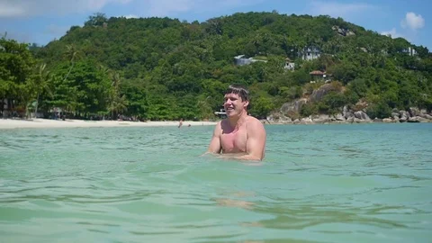 The happy guy makes a spray of water in the open sea Video stock 74924648