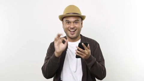 Happy Guy put on hat in casual clothes using mobile cell phone chatting just fou Stock Footage 144651426