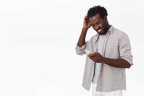 Happy guy receive message from his date in app, smiling and blushing pleased Stock Photos