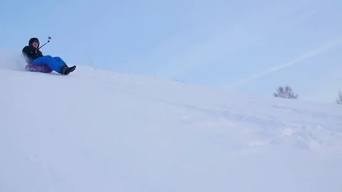 Happy guy rides and smiling snowtube on snowy roads.slow motion. snow winter 库存影片 72115602
