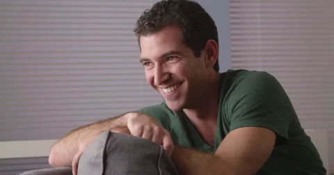 Happy guy sitting on couch Video stock 42583859