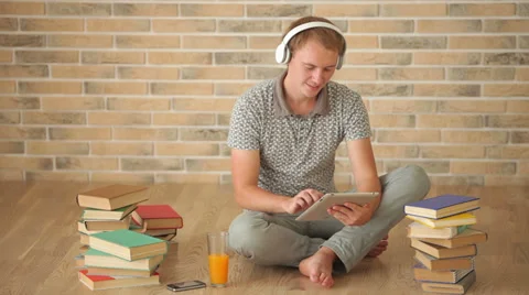 Happy guy sitting on floor using touchpad looking at camera and smiling Stock Footage 34278359