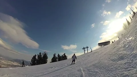 Happy guy on a skiing sliding down the slope at sunny day Vídeos de archivo 74631651