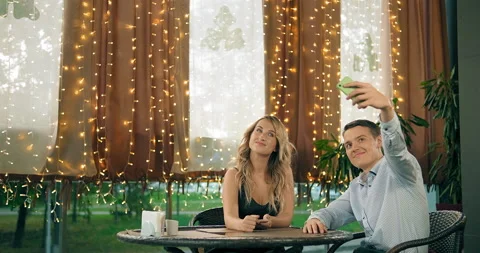 Happy guy with smiling girlfriend makes selfie in cafe Stockbeeldmateriaal 142490042