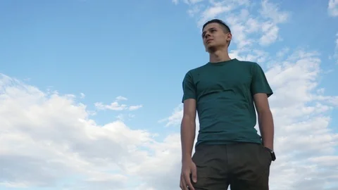 Happy guy standing and looking at the Black Sea under celeste sky in slo-mo Stock-Footage 113113622