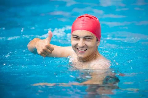 Happy guy in a swimming cap in the pool. Stock Photos
