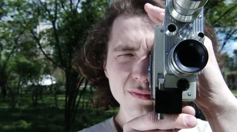Happy guy takes old video, cinema in park city, slow motion, 4K UHD UltraHD Video stock 65017852