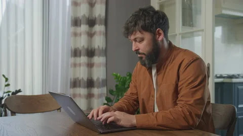 Happy guy taping on a laptop computer Stockbeeldmateriaal 201233636