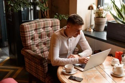 Happy guy typing on computer in coffee shop Foto stock