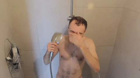 The happy guy is washing in the shower Stock Footage 86353632