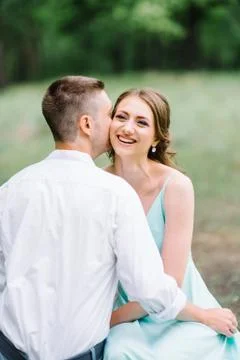 Happy guy in a white shirt and a girl in a turquoise dress are walking in the Stock Photos