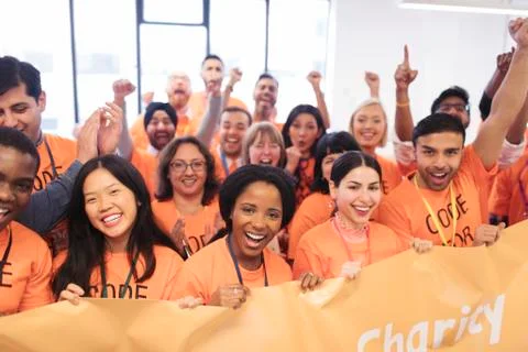 Happy hackers with banner cheering, coding for charity at hackathon Stock Photos