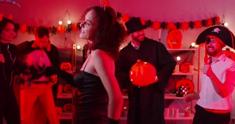 Happy Halloween holiday demon devil woman in black dress dancing with friends Stock Footage 338257652