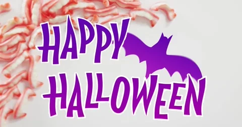 Happy halloween text banner with bat icon against halloween candies on grey Stock Footage 329283121