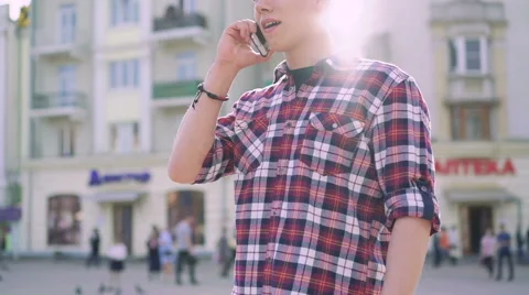 Happy handsome boy speaking on a mobile phone on a sunny street Stock-Footage 62014871