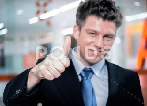 Happy handsome business man holding thumbs up Stock Photos