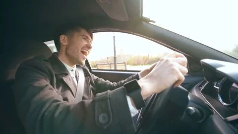 Happy handsome businessman driving car and singing. Man is happy after making Stock Footage