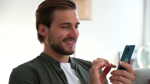 Happy Handsome Caucasian Man Using Smartphone at Home, Browsing the Internet Stock Footage 220864372
