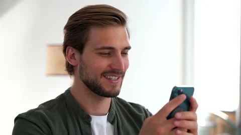 Happy Handsome Caucasian Man Using Smartphone at Home, Browsing the Internet Stock Footage 220865434