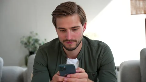 Happy Handsome Caucasian Man Using Smartphone at Home, Browsing the Internet Stock Footage 220865901
