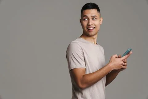 Happy handsome guy using mobile phone and smiling Stock-Fotos