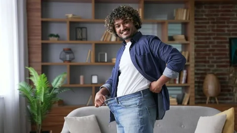 Happy handsome man feels joy after losing weight. Smiling satisfied young adult  Vídeos de archivo 334230837