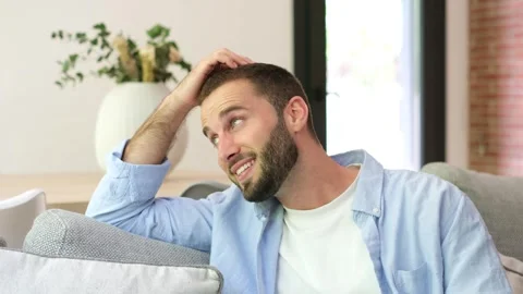 Happy handsome man relaxing on a sofa Stock Footage 335588490