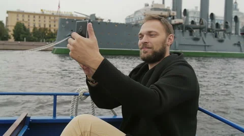 Happy handsome man sightseeing in St Petersburg. Taking selfie in front of Video stock 67998397
