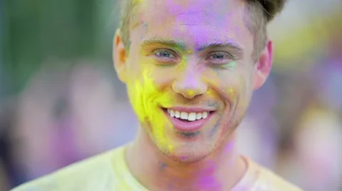 Happy handsome man smiling to camera, enjoying atmosphere at color festival Stock Footage 66633423