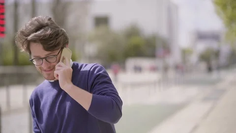 Happy handsome man talking by cell phone outdoor Stock Footage 107134228