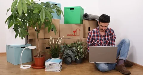 Happy Handsome Man Using a Computer Laptop Working at Home Design New Apartment Stock Footage 87908985