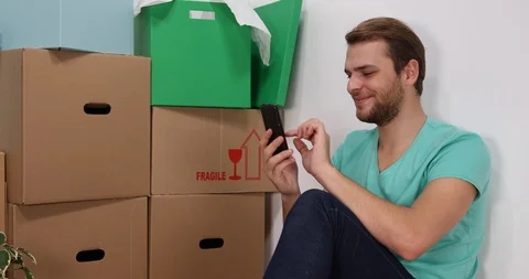 Happy Handsome Man Using Mobile Phone Working at Home Design for New Apartment Video stock 87984491