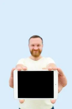 Happy Handsome young man with a beard showing something on a tablet isolated  Stock Photos