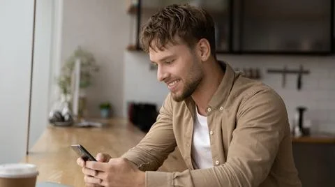 Happy handsome young man using cellphone apps. Foto stock