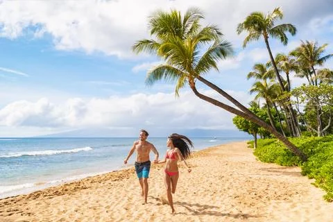 Happy Hawaii beach fun young people running enjoying summer vacations in Maui Stock Photos