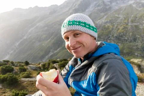 Happy Hiker eats an apple during a break in the Swiss alps Foto stock