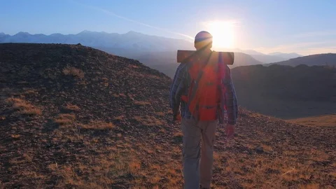 Happy hiker traveler man with backpack climbing up, standing on top of mountain Stock Footage