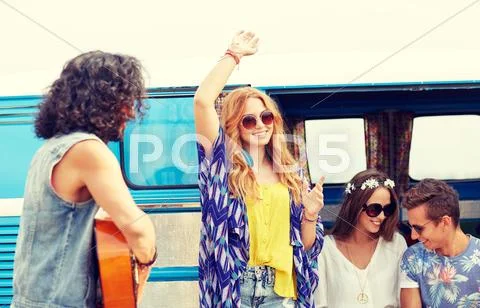 Happy hippie friends having fun over minivan car Stock Photos