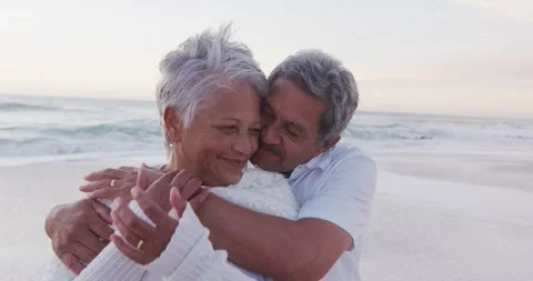 Happy hispanic just married senior couple embracing on beach at sunset Stock Footage 342491449