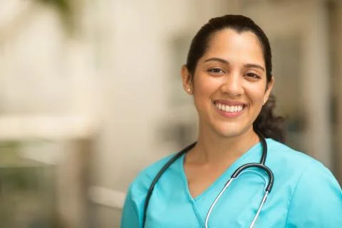 Happy Hispanic medial provider at work stock photo. Stock Photos