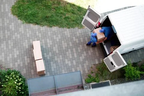 Happy Hispanic Mover Unloading Mattress From Furniture Delivery Truck Today. Stock Photos