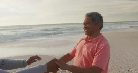 Happy hispanic senior couple dancing on beach at sunset Stock Footage 339555705